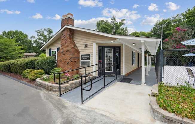 A small building with a brick chimney and a black gate.