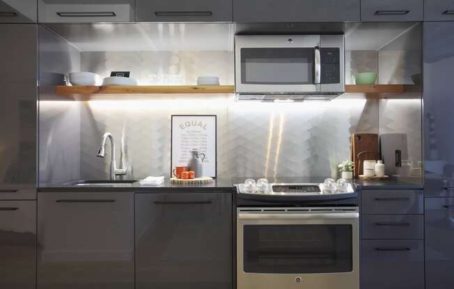 a small kitchen with gray cabinets and stainless steel appliances