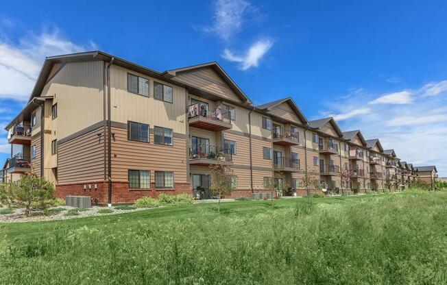 a large brick building with a grassy field