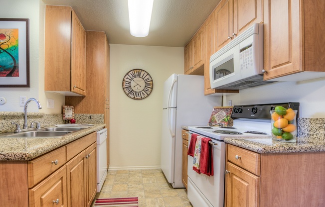 A kitchen with wooden cabinets and a white refrigerator.