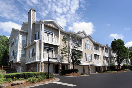 the exterior of an apartment building with a parking lot