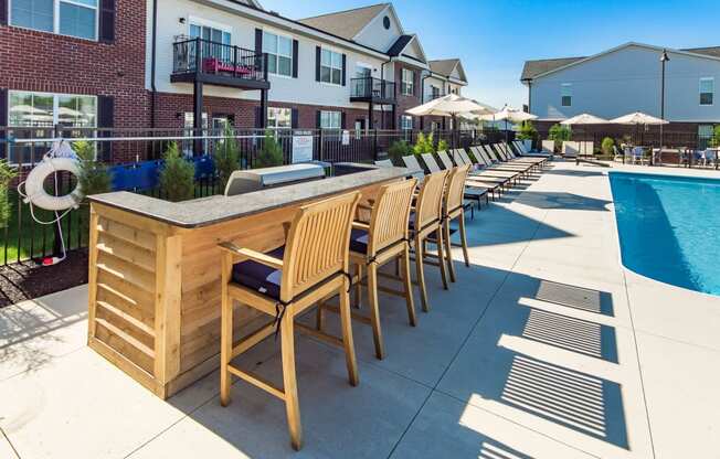 bar with chairs next to pool