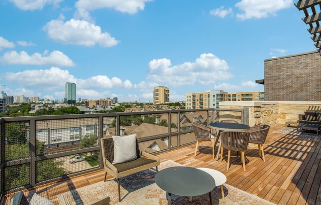 a balcony with a table and chairs and a view of the city