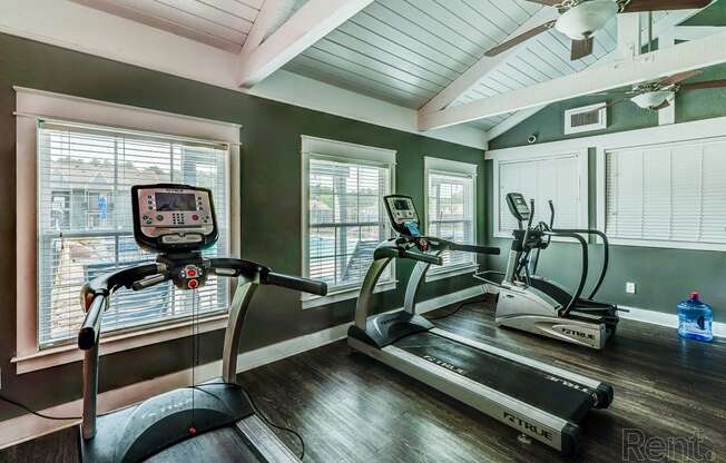 a home gym with exercise equipment and windows