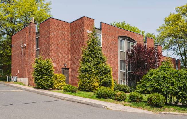 a red brick building with a street in front of it at Springwood Gardens, New Britain, CT, 06053