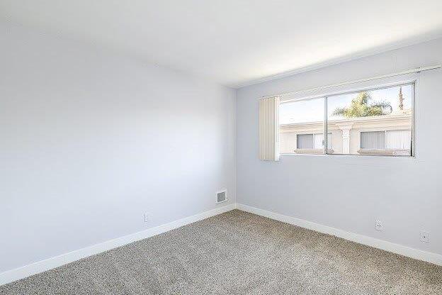 A room with a window showing a building outside.