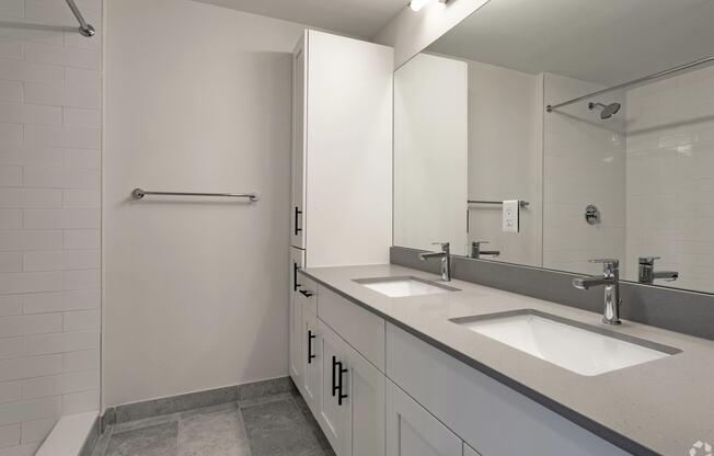 a bathroom with two sinks and a shower