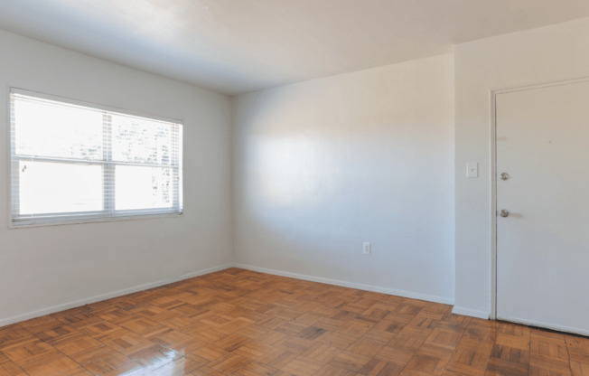 A room with a wooden floor and a window.