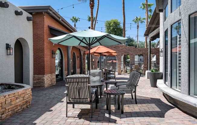 A patio with a table and chairs under an umbrella. at Lazo Apartment Homes, Arizona