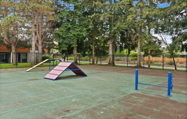 a playground with a slide and rails in a park