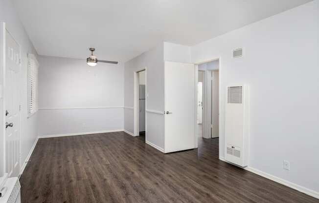 an empty living room with white walls and wood flooring