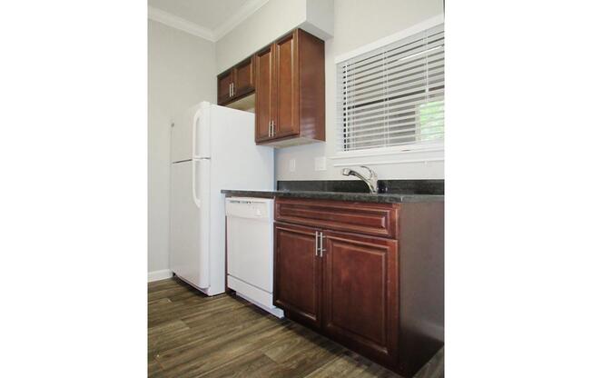 a kitchen with wooden cabinets and a refrigerator