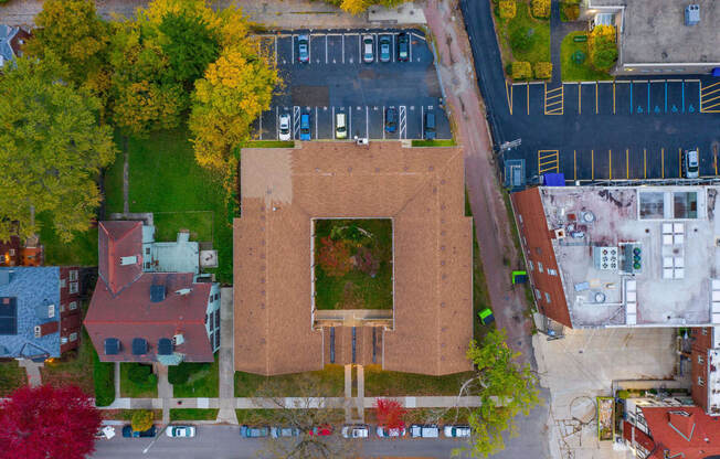 an aerial view of a brick building with a green roof