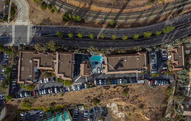 A bird's eye view of a residential area with houses and parked cars.