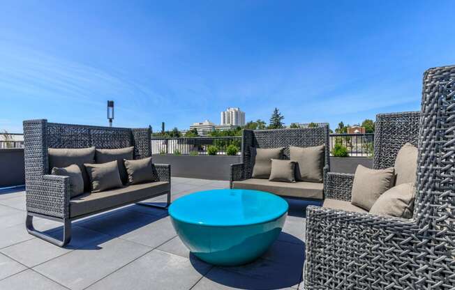 a seating area with couches and a coffee table on a rooftop patio
