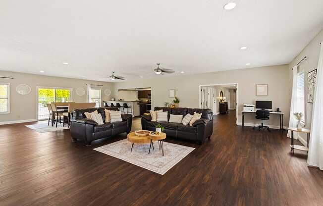 A spacious living room with dark wood floors and furniture.