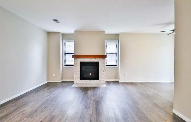 A room with a fireplace and wooden floors.