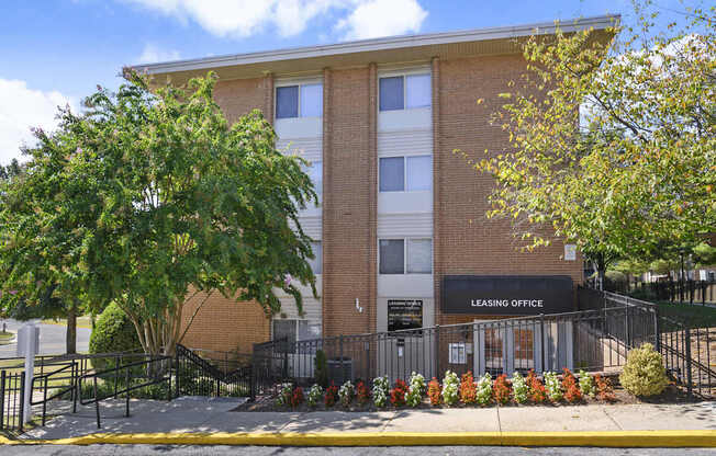 A brick building with a leasing office on the ground floor.