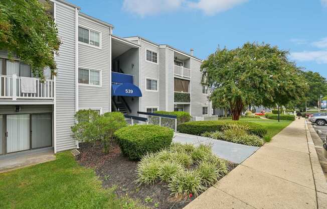 Exterior view of our apartments with a sidewalk and landscaping in front at ReNew Odenton