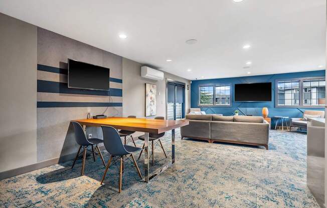 A modern living room with a wooden table and blue chairs.