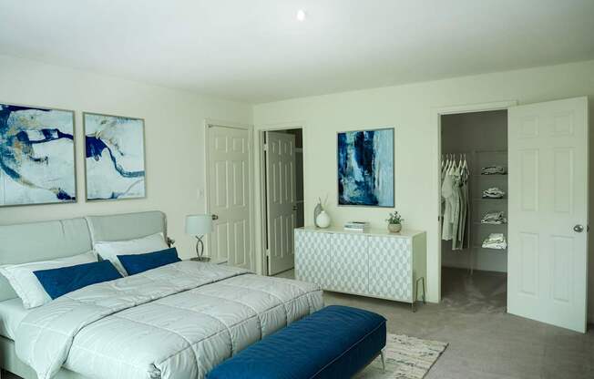 A bedroom with a large bed and a dresser with a mirror.