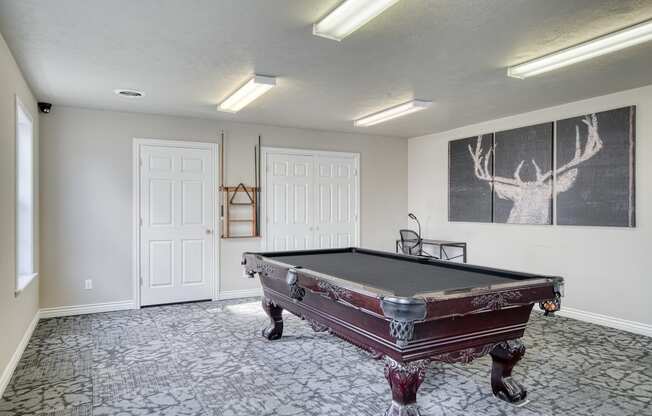 a game room with a pool table and a chalkboard on the wall