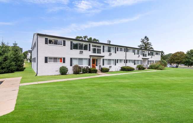 the view of an apartment building with a green lawn