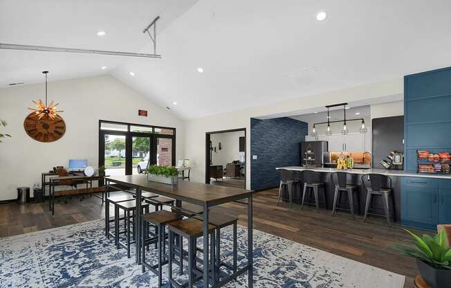 a dining area with a table and chairs and a kitchen in the background