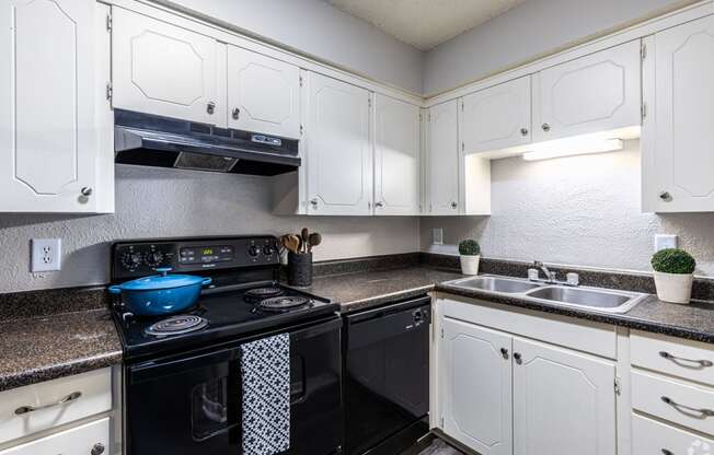 a kitchen with black appliances and white cabinets