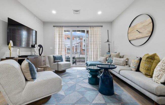 A modern living room with a large window and a view of a building outside.