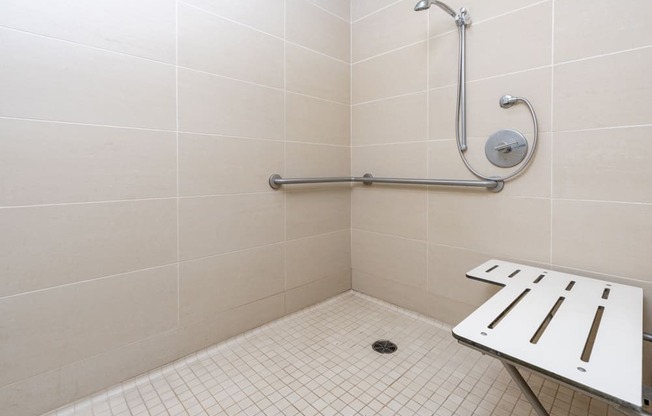 a bathroom with a shower and a stool in it