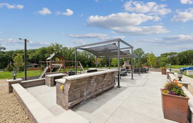 a patio with a seating area and a playground in a park