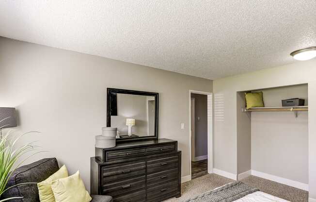 a living room with a couch and a dresser and a mirror