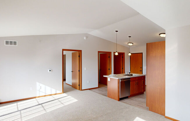an empty living room and kitchen with a counter top