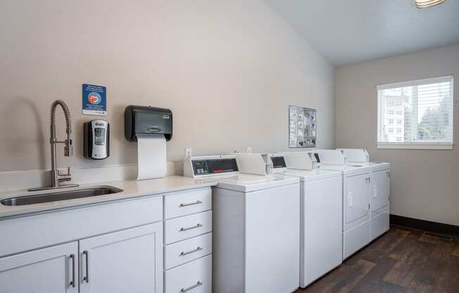 a laundry room with washers and dryers