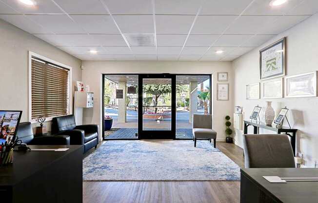 A reception area with a black couch, a desk, and a framed picture on the wall.