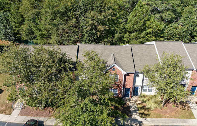 A building with a grey roof is surrounded by trees.