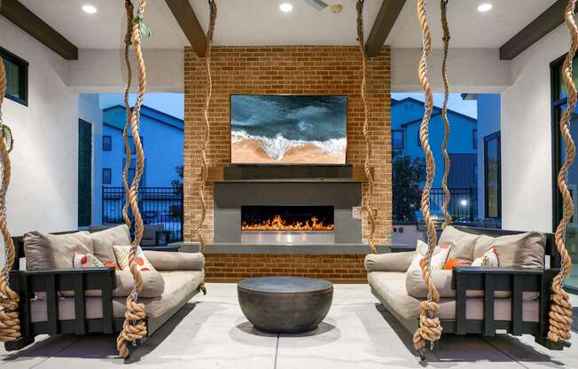 A modern living room with a fireplace and a painting of a beach scene on the wall.