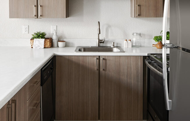 a kitchen with dark wood cabinets and white countertops