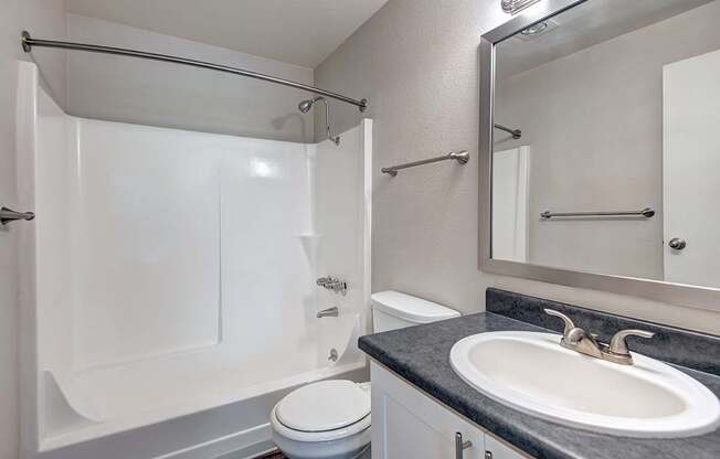 a bathroom with a sink toilet and shower and a mirror