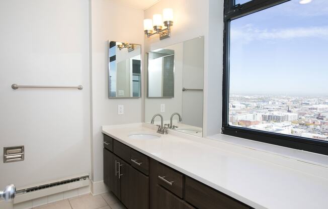 a bathroom with a large window and a sink and mirror at Apartments at Denver Place, Colorado