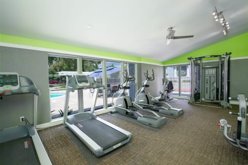 Fitness Center with cardio equipment and windows overlooking a pool