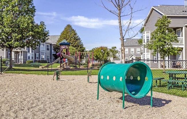 a playground with a slide and monkey bars in front of a house