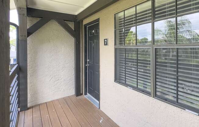 a front porch with a door and windows