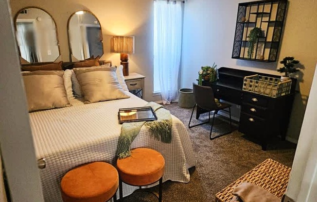 A bedroom with a bed, desk, and chair.