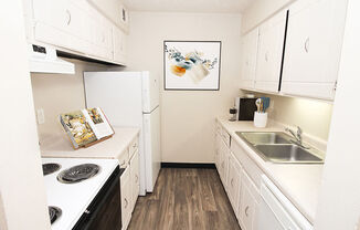 a kitchen with white cabinets and appliances
