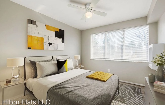a bedroom with a large bed and a ceiling fan