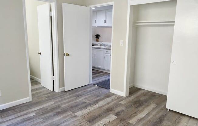 a bedroom with white walls and a hardwood floor at South Pointe Apts, Covina, CA 91722