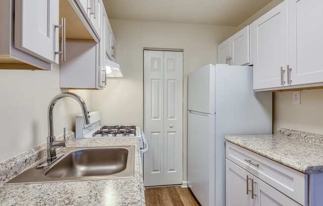 a kitchen with white cabinets and a sink and a refrigerator at Gates of West Bay in Norfolk, VA 