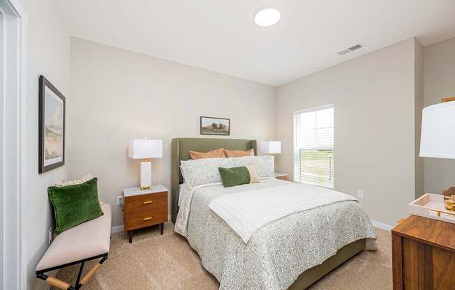 A bedroom with a large bed and a chair.